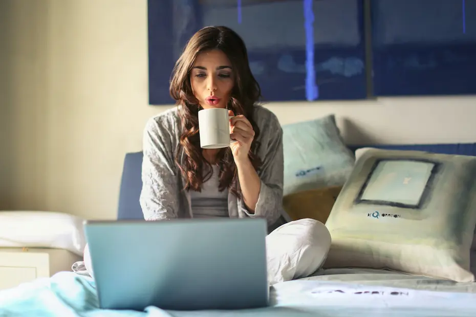 A Woman drinking a coffee while working.